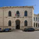 Costeggiando il perimetro della scuola torniamo in largo San Sabino e raggiungiamo il portone in legno di ingresso dell�edificio...